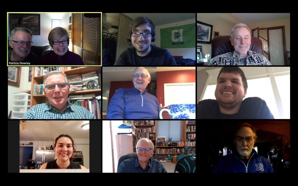 A screen shot of an online virtual meeting featuring nine frames of two women and eight men of varying ages who are mostly smiling.